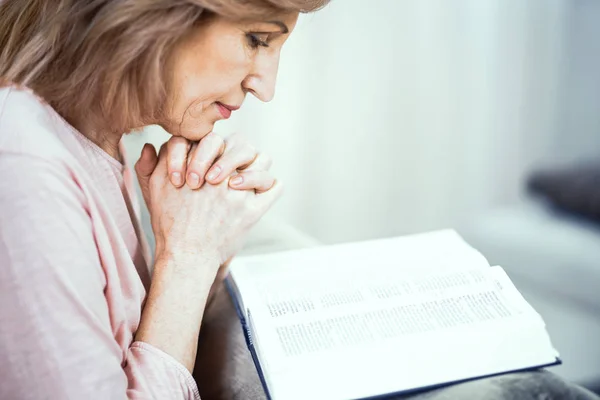 Beautiful mature woman is reading a book