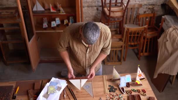 Handsome young craftsman making canvas for ship figures — Stock Video