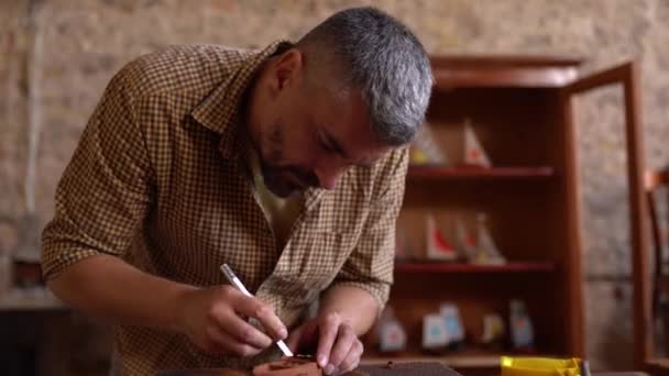 Tvrdě pracující crafsman pracuje na malém dřevěném člunu — Stock video