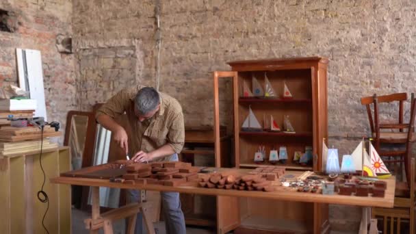 Artesano trabajador trabaja en un pequeño barco de madera — Vídeos de Stock