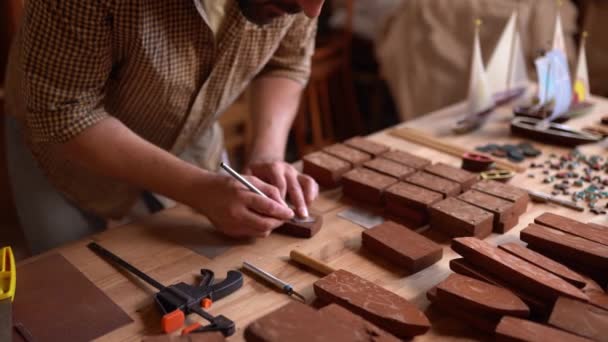 Un artisan travailleur travaille sur un petit bateau en bois — Video