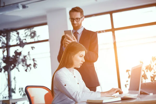 Compañeros ocupados trabajando en una oficina soleada — Foto de Stock