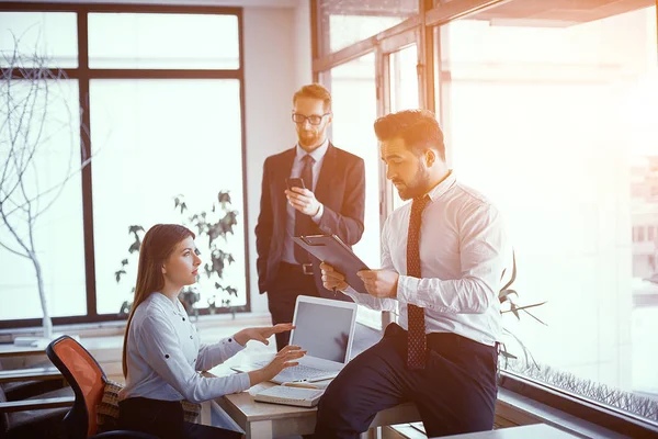 Succesfull uomini d'affari che studiano documenti in ufficio soleggiato — Foto Stock