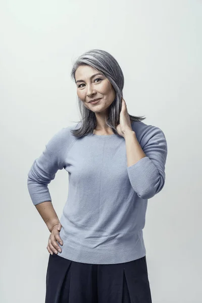 Schöne Asiatin mit weißem Haar lächelnd an der Wand stehend — Stockfoto