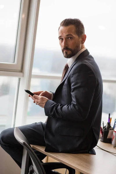 Hombre de negocios guapo sentado en el escritorio en la oficina — Foto de Stock