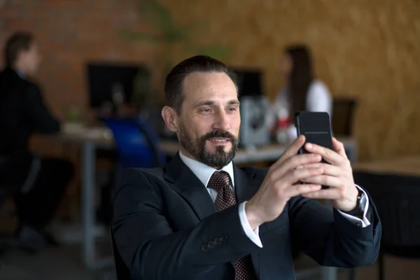 Ευτυχισμένος επιχειρηματίας κάθεται στο τραπέζι και να κάνει selfie — Φωτογραφία Αρχείου