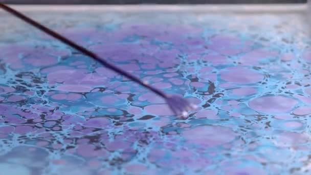 Artista crea diseño de ebru ausente con pinturas azules y violetas — Vídeo de stock