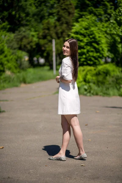 Perfil de joven sonriente morena mujer está en el parque . —  Fotos de Stock