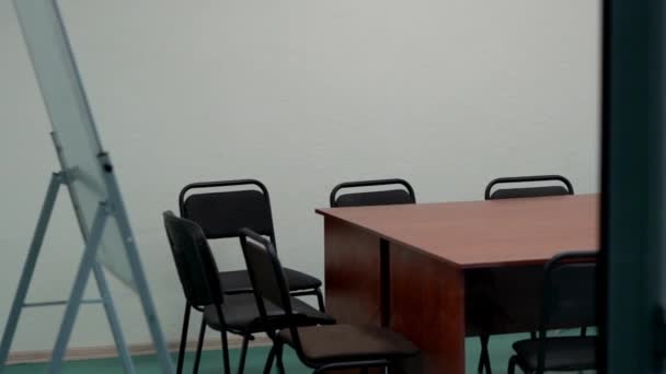 Interior of an office with wooden large desk and many black chairs. — Stock Video