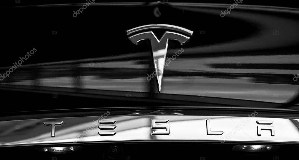 Metal Sign on Tesla Electric Vehicle and Tesla Lettering. Beautiful Logo Reflects Light. Close-Up Automobile Back Part. Kyiv, Ukraine, F-Drive showroom 13 of february 2018.