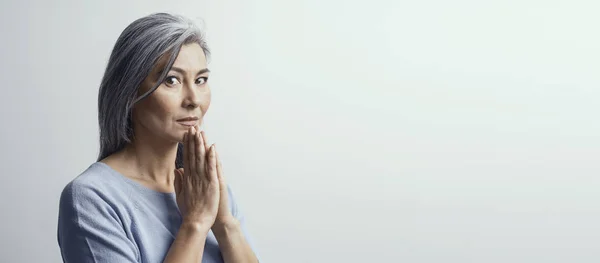 Rijpe Aziatische vrouw bidden op witte achtergrond — Stockfoto