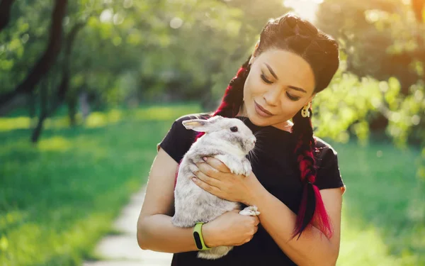 Bastante asiático chica abrazando conejito en verano naturaleza — Foto de Stock