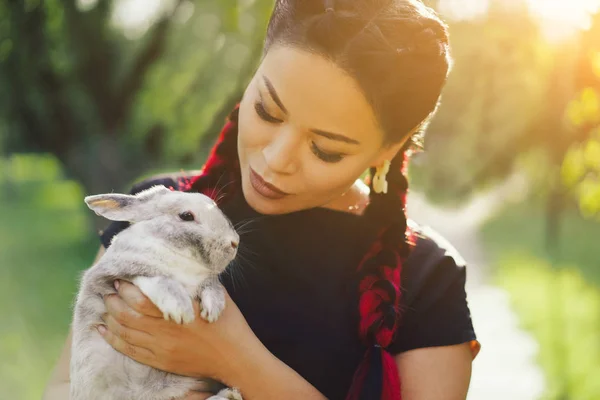 Bastante asiático chica abrazando conejito en verano naturaleza — Foto de Stock