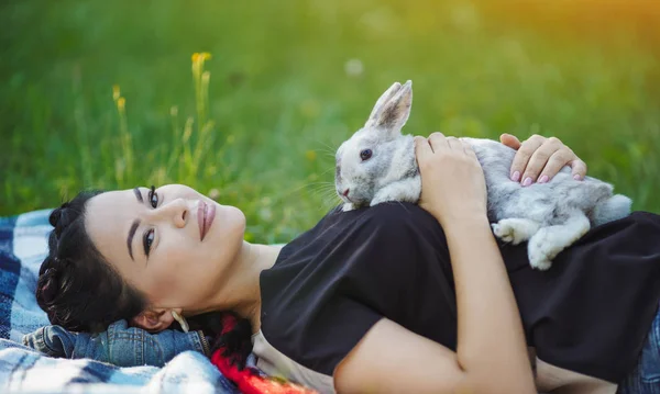 Hermosa mujer asiática madura está acostada en el suelo y abrazando a un conejo — Foto de Stock