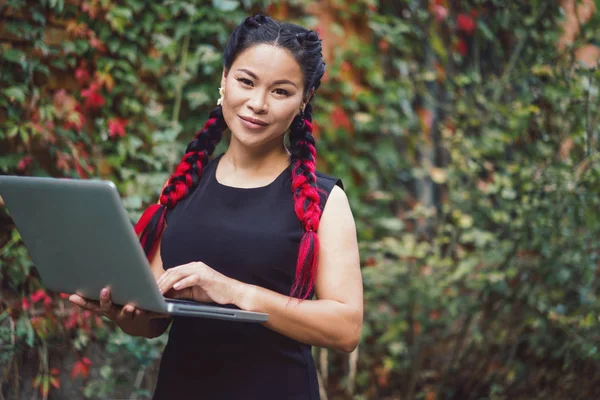 Mooie Aziatische zakenvrouw poseren met laptop buiten — Stockfoto