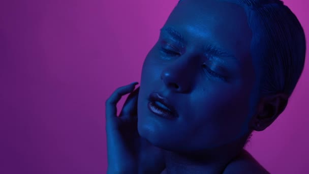 Vacker kvinnlig modell poserar i blått och rosa neonljus i studion — Stockvideo