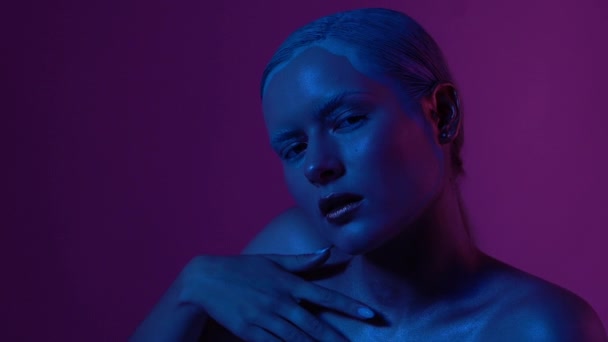 Gyönyörű női modell pózol, kék és rózsaszín Neonfény a stúdióban — Stock videók