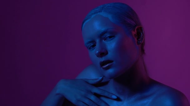 Schönes weibliches Model posiert in blauem und rosa Neonlicht im Studio — Stockvideo