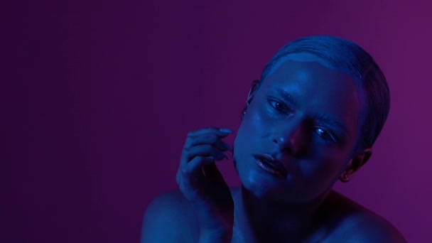 Schönes weibliches Model posiert in blauem und rosa Neonlicht im Studio — Stockvideo