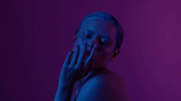 Modelo feminino bonita posando em luz de néon azul e rosa em estúdio — Vídeo de Stock