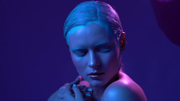 Hermosa modelo femenina posando en luz de neón azul y rosa en el estudio — Vídeo de stock