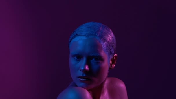 Schönes weibliches Model posiert in blauem und rosa Neonlicht im Studio — Stockvideo