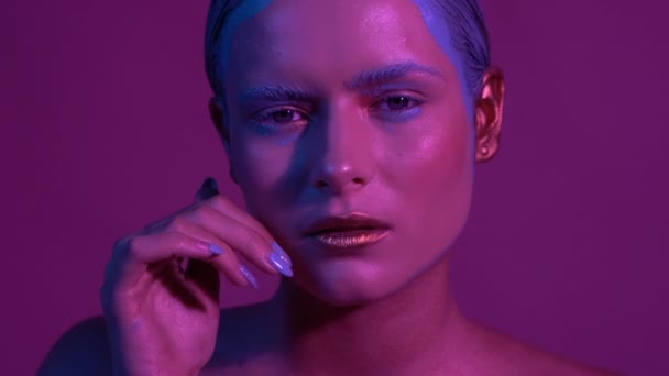 Όμορφο θηλυκό μοντέλο που ποζάρει σε μπλε και ροζ φως νέον στο στούντιο — Αρχείο Βίντεο