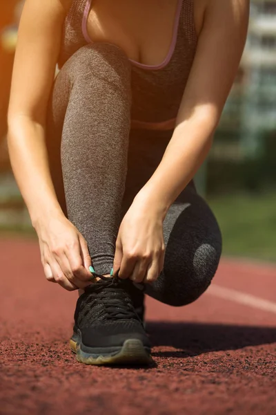 Jong sportief meisje met krullend kapsel op zomer stadion — Stockfoto