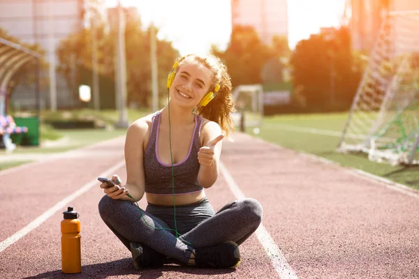 Молодая спортивная девушка с кудрявой прической на летнем стадионе — стоковое фото