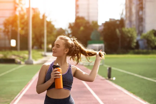 Fiatal sportos lány göndör frizurával a stadionban — Stock Fotó