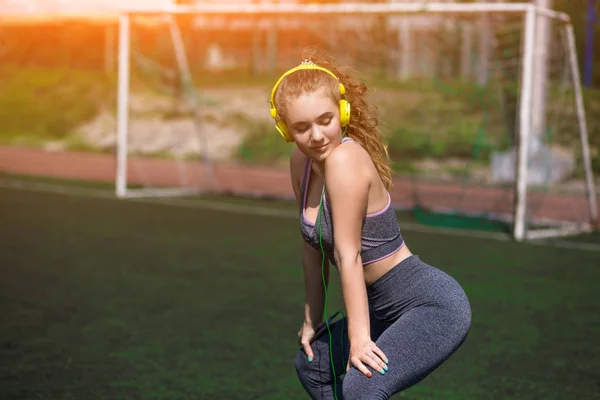 Молодая спортивная девушка с кудрявой прической на стадионе — стоковое фото