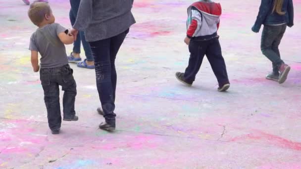 Multitud de niños y adultos caminan sobre un colorido asfalto — Vídeos de Stock