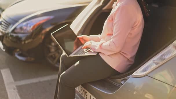 Mujer de negocios está escribiendo en el ordenador portátil fuera . — Vídeos de Stock