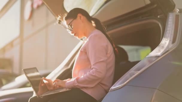 Mujer de negocios está escribiendo en el ordenador portátil fuera . — Vídeos de Stock