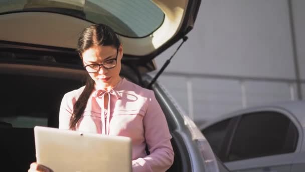 Mujer de negocios está escribiendo en el ordenador portátil fuera . — Vídeos de Stock