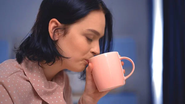 La hermosa joven bebiendo té o café en casa —  Fotos de Stock