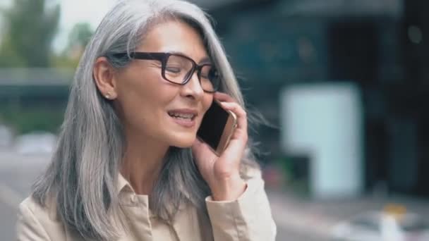 Die asiatische Frau mittleren Alters telefoniert — Stockvideo