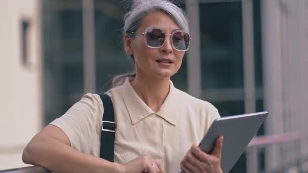 La femme d'affaires asiatique debout avec un ordinateur tablette à l'immeuble de bureaux — Video