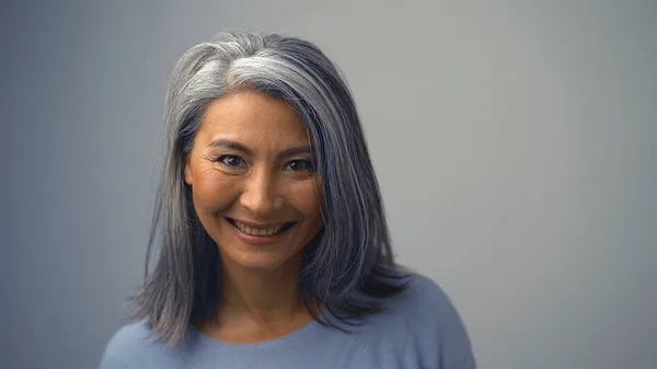 Smiling Asian Woman With Wrinkles Near Her Eyes