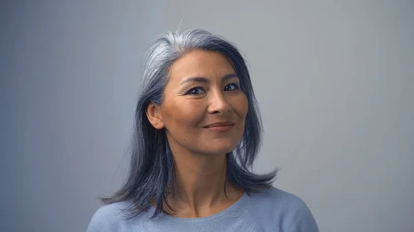Sonriente mujer asiática en el fondo gris — Foto de Stock