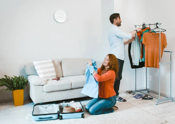 Viagens em família, marido e mulher fazendo malas para férias . — Fotografia de Stock