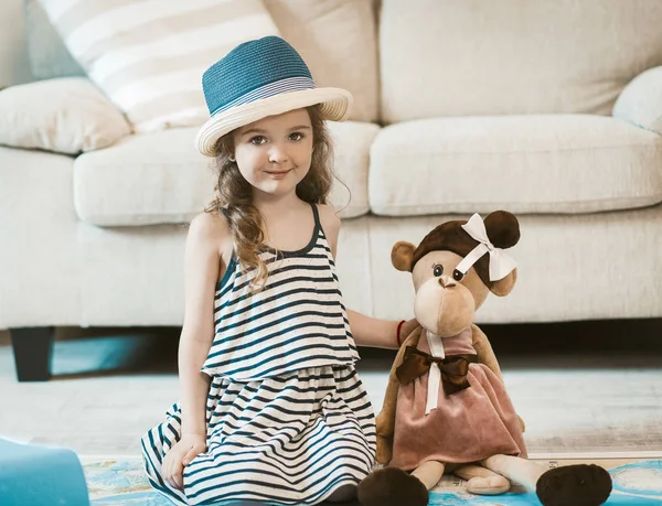 Retrato de adorável menina sentada no tapete . — Fotografia de Stock