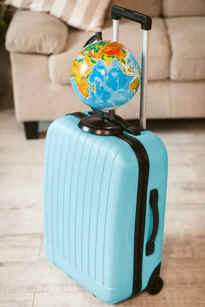 Närbild på ljus resväska med jordglob. — Stockfoto