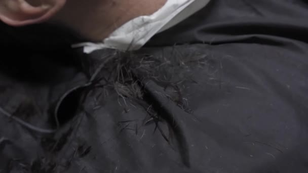 Primo piano sul taglio dei capelli sulle spalle del cliente al momento del taglio. Un uomo visita un salone di bellezza durante un periodo di quarantena pandemica. Prore 422 — Video Stock