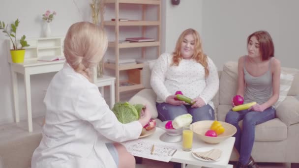 Διατροφολόγος δίνει συμβουλές σε κορίτσια με διαφορετικά προβλήματα βάρους μυρίζοντας λάχανο. Κορίτσι με πρόβλημα βάρους έκπληκτος με τις πληροφορίες. Σωστή διατροφική έννοια. Πρότυπα 422 — Αρχείο Βίντεο