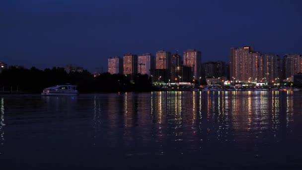 Coucher de soleil sur la ville avec un bateau flottant. Une ville moderne avec des immeubles résidentiels de grande hauteur. Août 2019. Kiev, Ukraine. Prores 422 — Video