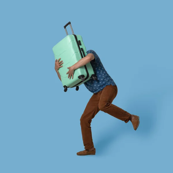 A futó férfi műanyag bőröndöt tart maga előtt. Fehér utazó világoszöld bőrönddel, aki próbál utolérni egy repülőt. Színes háttérrel elszigetelve. Táblázat szöveghellyel — Stock Fotó