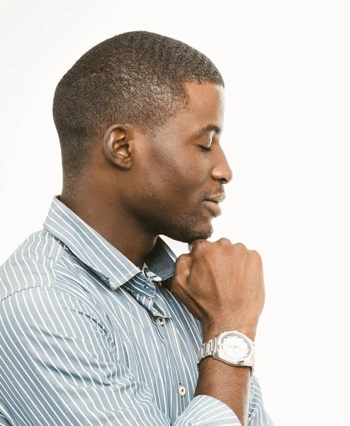 Bonito homem de negócios de cabelos curtos tocando seu queixo com punho. Um africano atencioso a usar camisa listrada com um relógio de pulso caro no fundo branco. Retrato de exibição de perfil. Imagem tonificada — Fotografia de Stock