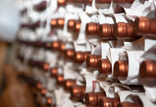 Reihen von Weinflaschen in einem Weinkeller gelagert. Weinflaschen werden in Papiertüten gelagert. Hintergrund oder Textur von Weinflaschen. April 2013. Eger, Ungarn — Stockfoto
