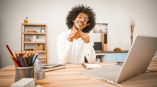 Divertido estudiante o freelancer divertirse cruzando lápices y mirando a la cámara. Trabajo desde el concepto de casa. Concepto de educación en el hogar. Imagen tonificada — Foto de Stock